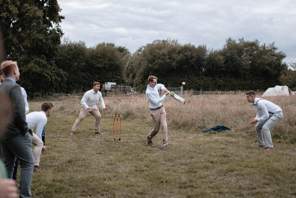 Documentary-style wedding photography of the wedding party playing outdoor games