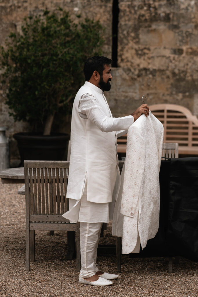 A second wedding photographer capturing the groom getting ready for his wedding day