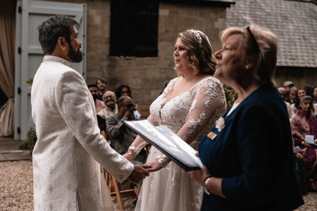 A second wedding photographer capturing the bride and groom during their wedding ceremony