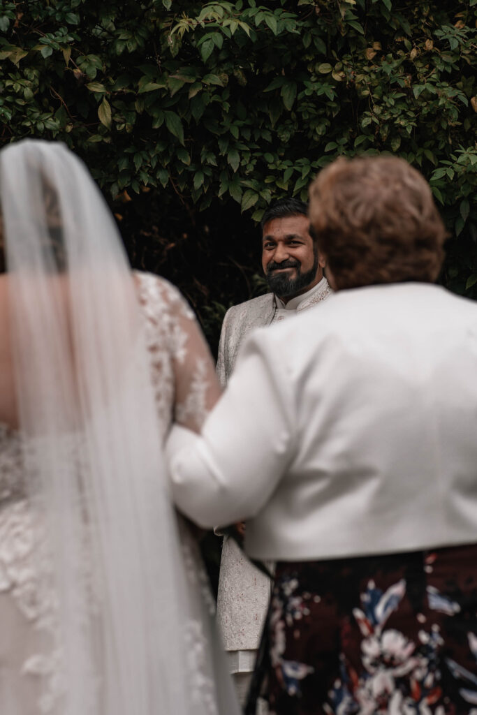 A second wedding photographer capturing the bride and groom during their wedding ceremony