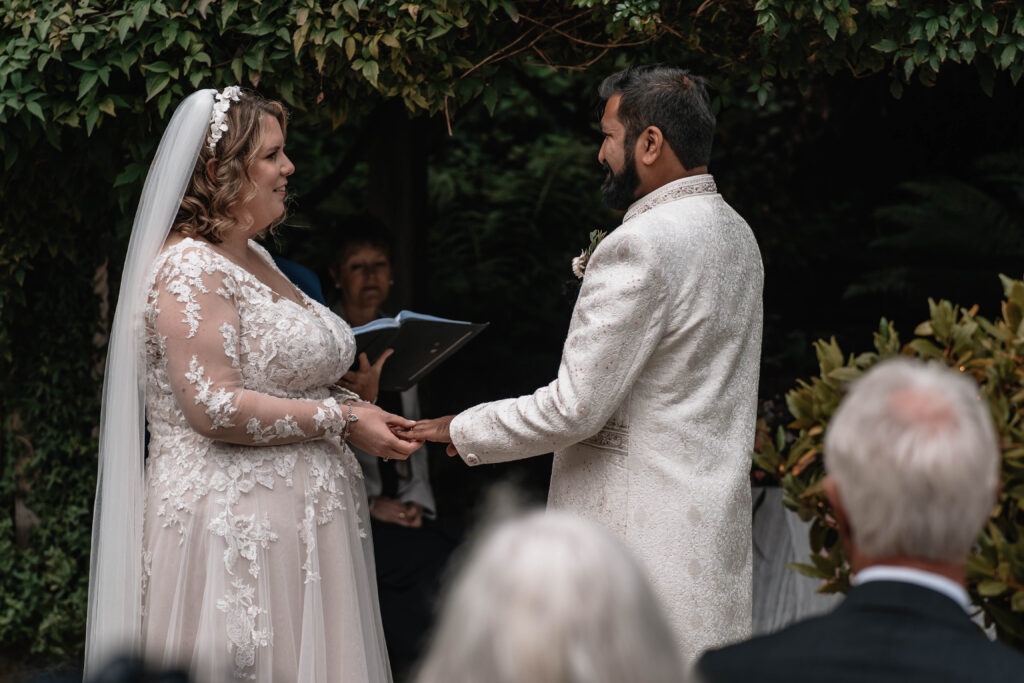 A second wedding photographer capturing the bride and groom during their ceremony