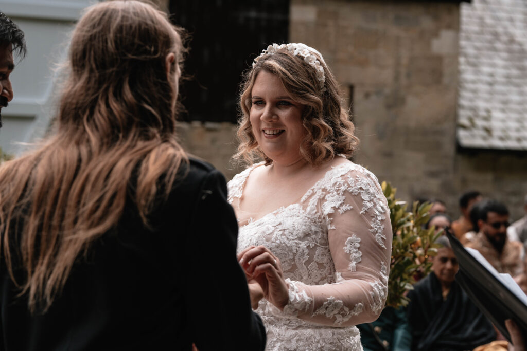 A second wedding photographer capturing the bride during the ceremony