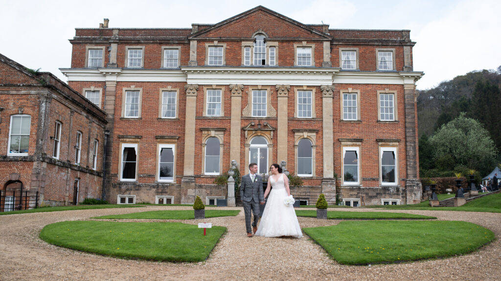 The bride and groom standing outside of their wedding venue in Somerset