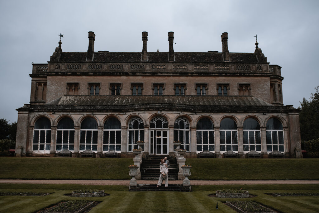 The bride and groom standing outside of their wedding venue in Somerset