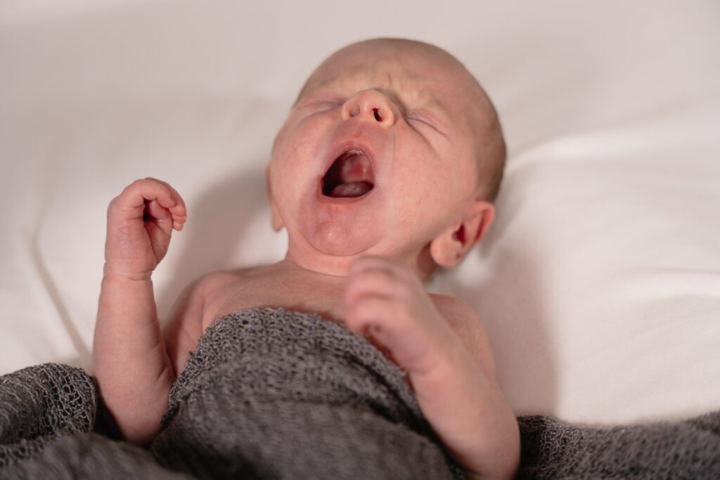 Newborn photography of baby yawning
